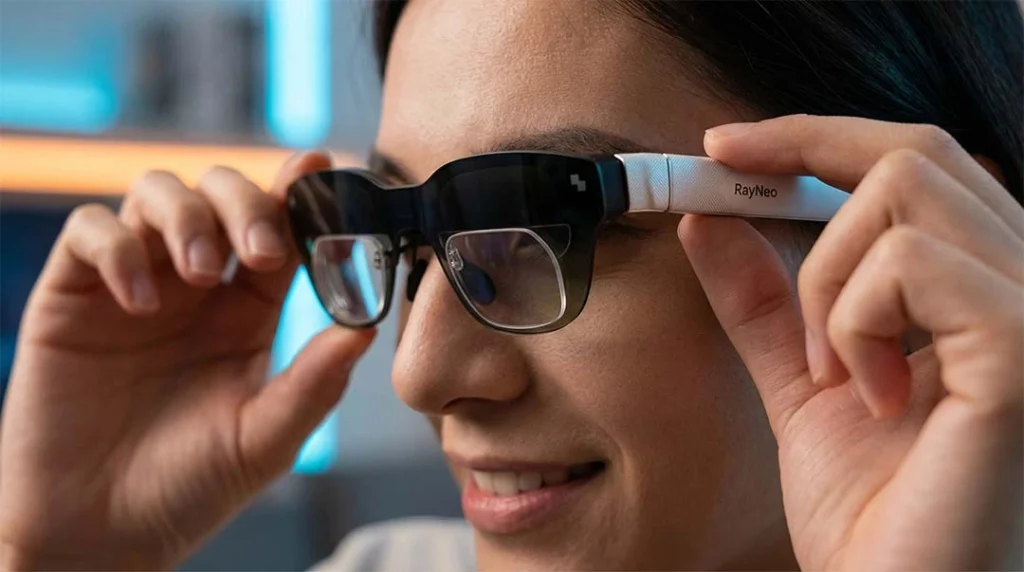 A person's hands gently shifting a pair of black AR smart glasses slightly up and down on their face.